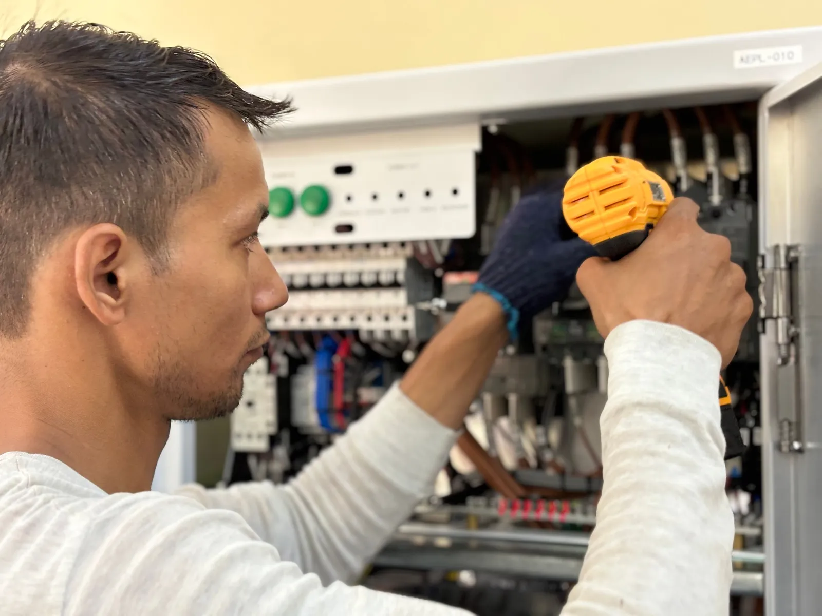 Electrician working inside an open circuit breaker panel — illustrative stock photo, not an actual East Valley job site
